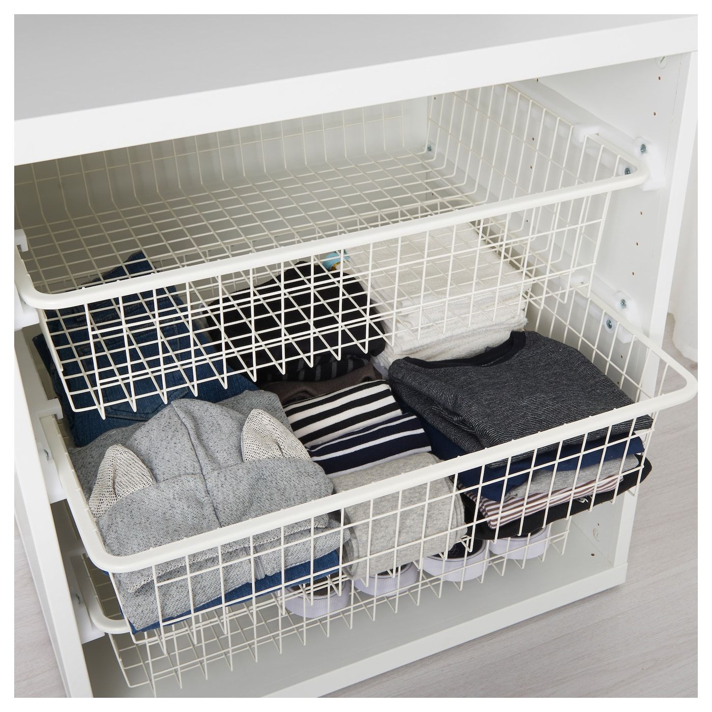 Wire baskets storing handbags and hats, mounted inside a wardrobe door.